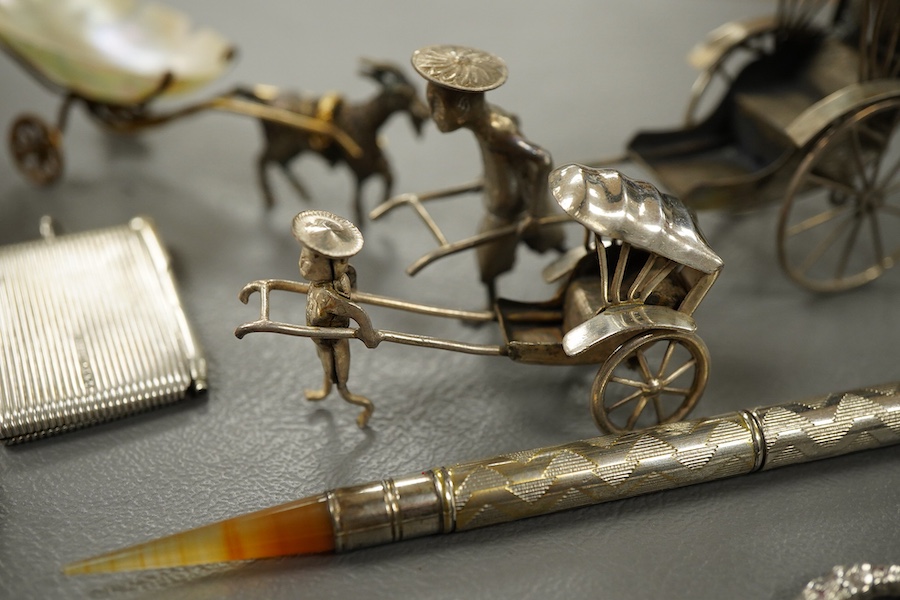 Sundry small silver and other items including a pig pin cushion, Adie & Lovekin, Birmingham, 1906, 45mm, a silver circular stamp case, a silver vesta case, a small sterling mounted notecase, three small metal rickshaws,